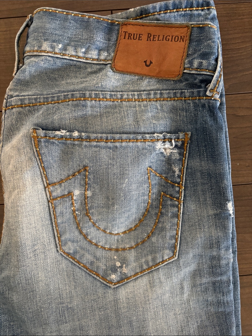 True Religion light blue distressed denim jeans with tan leather patch
